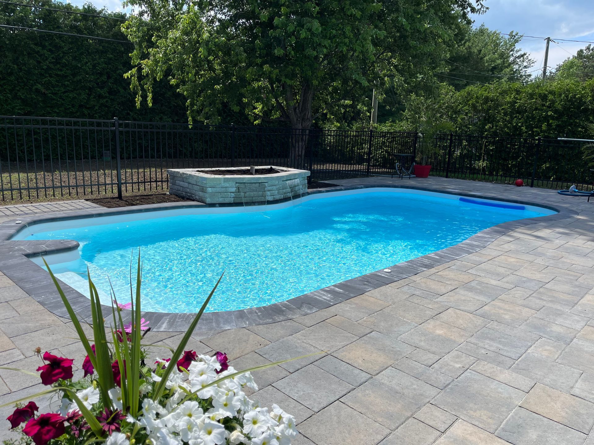 Une grande piscine avec un foyer dans l'arrière-cour.