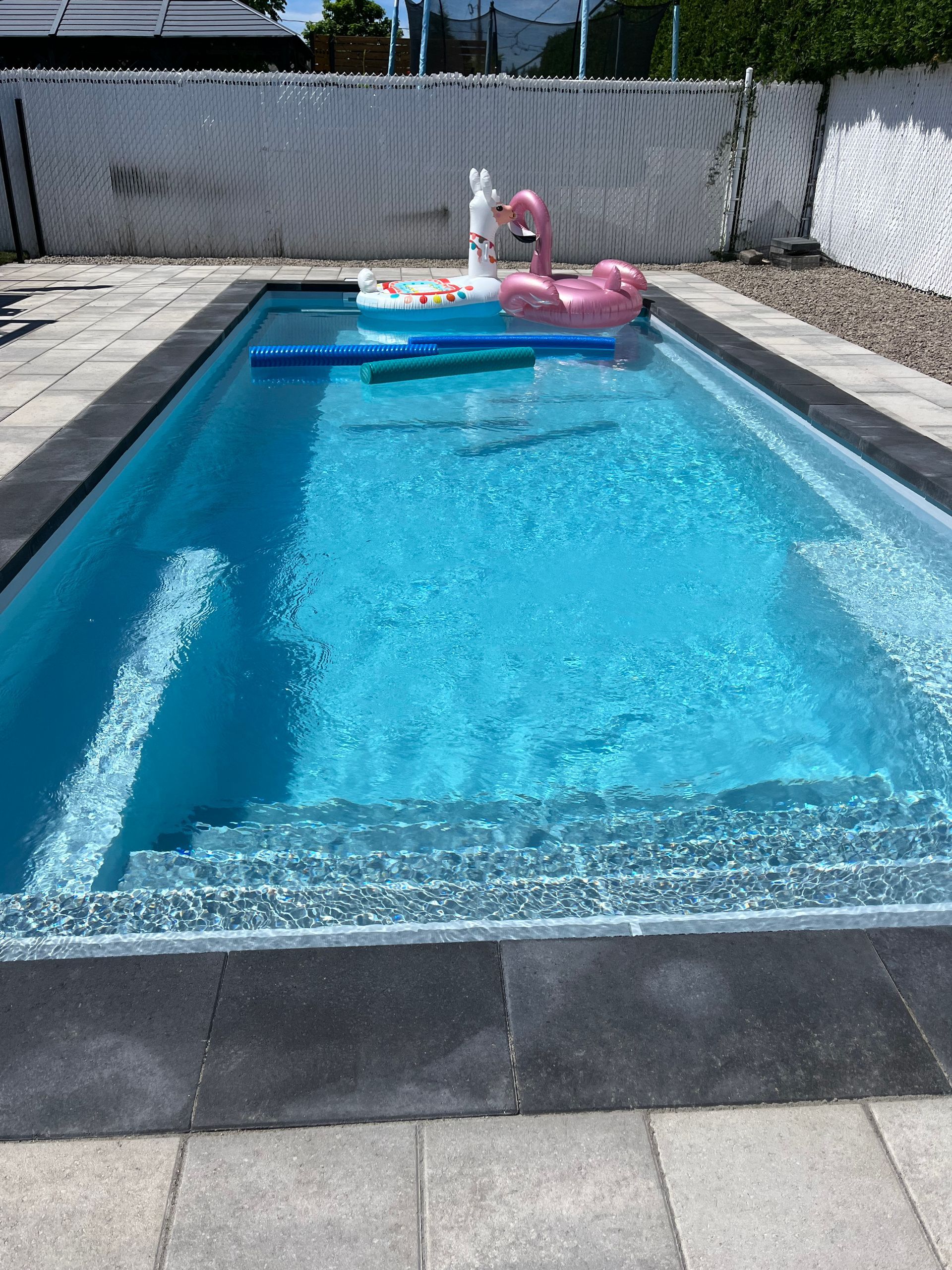 Une grande piscine avec un flotteur de flamant rose dedans.