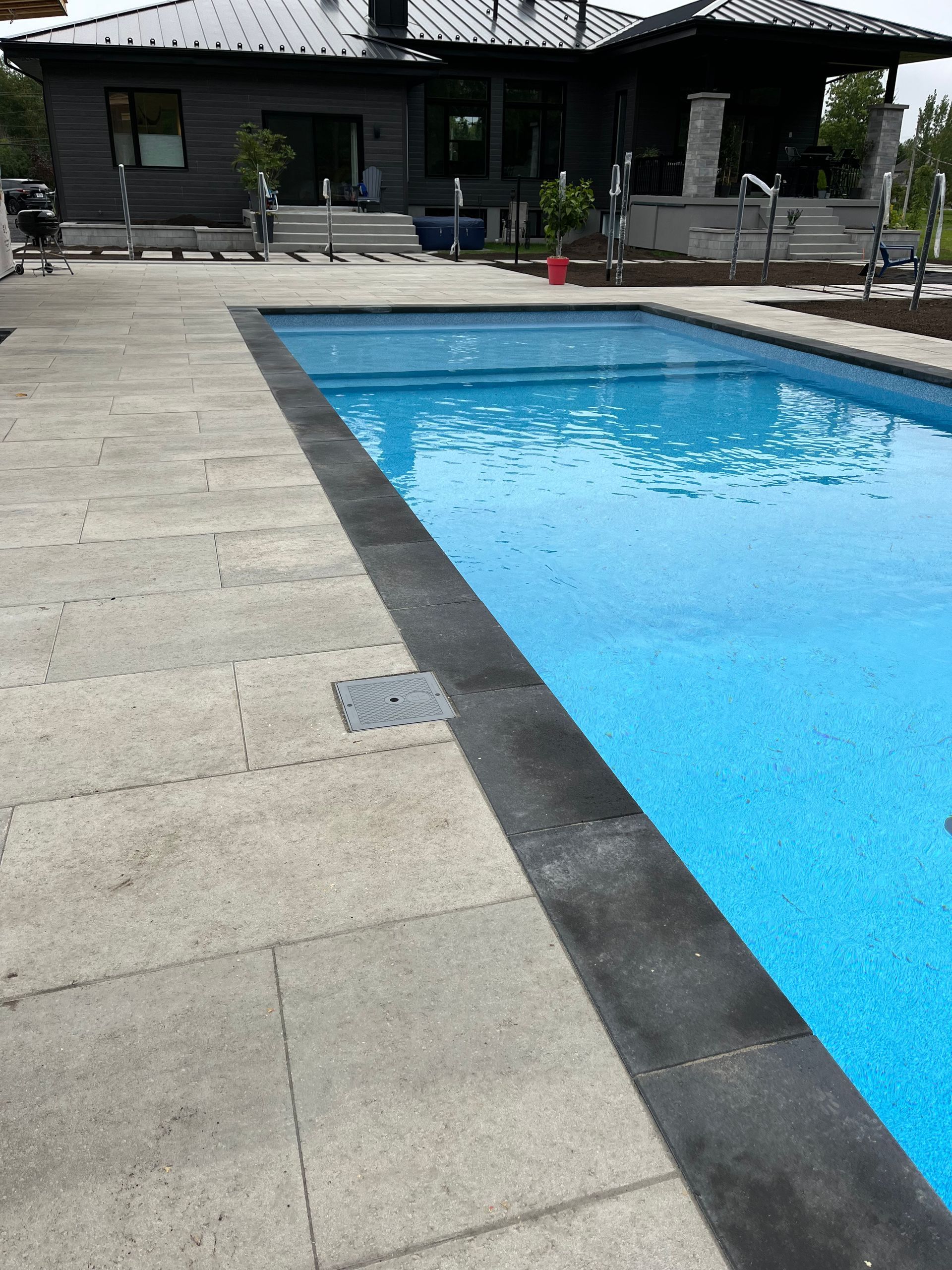 Une grande piscine avec une maison en arrière-plan