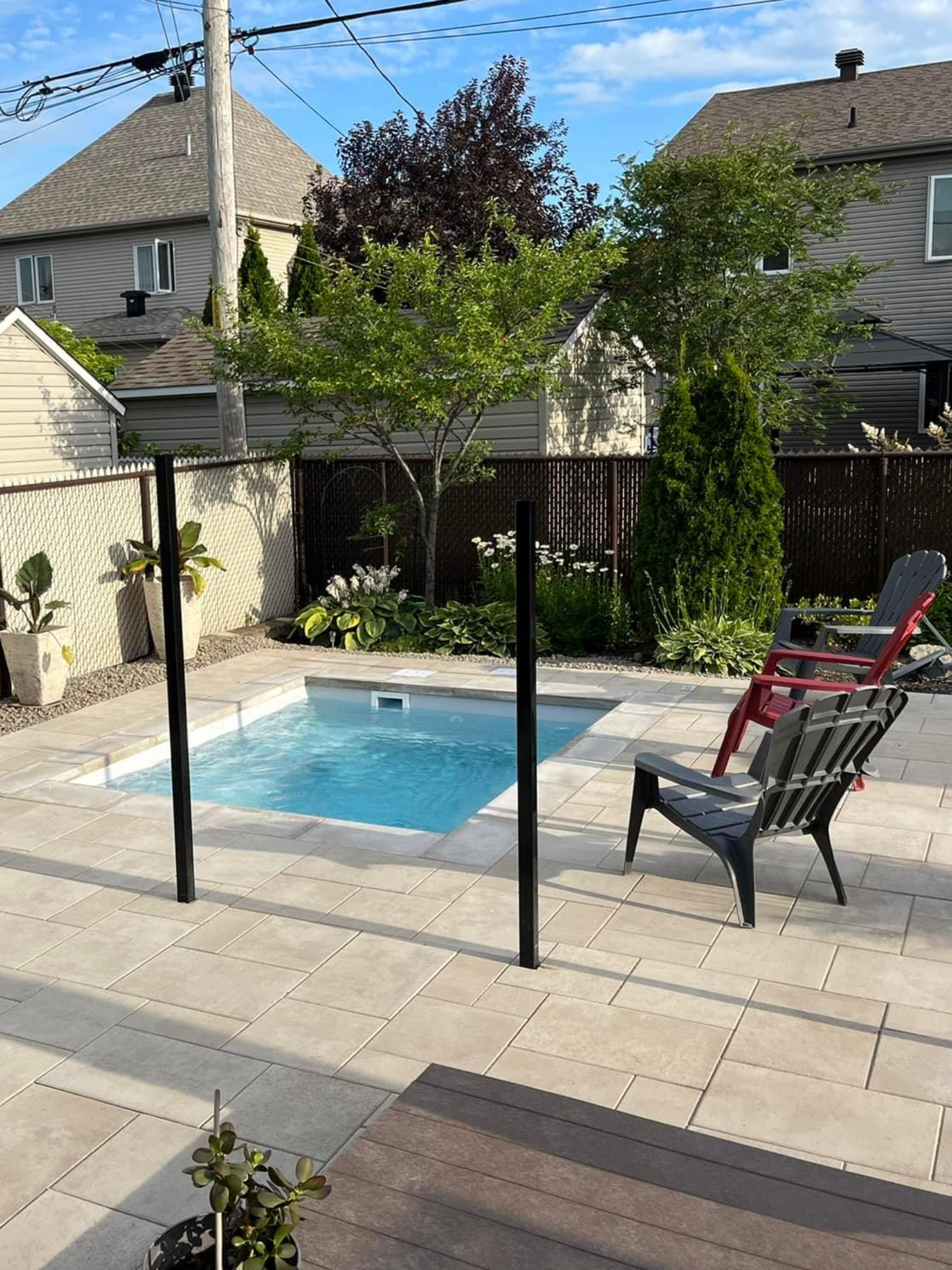 Un patio avec une chaise et une piscine dans l'arrière-cour