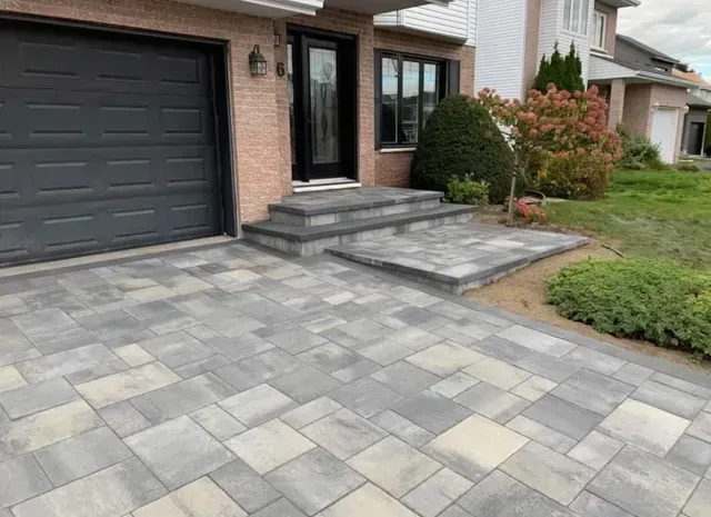 Une allée avec des marches menant à la porte d'entrée d'une maison.