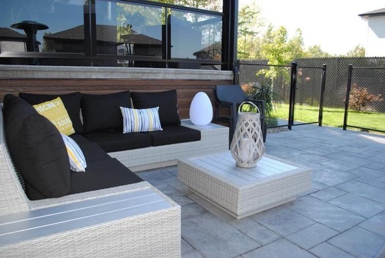 Un patio avec un canapé sectionnel et une table basse