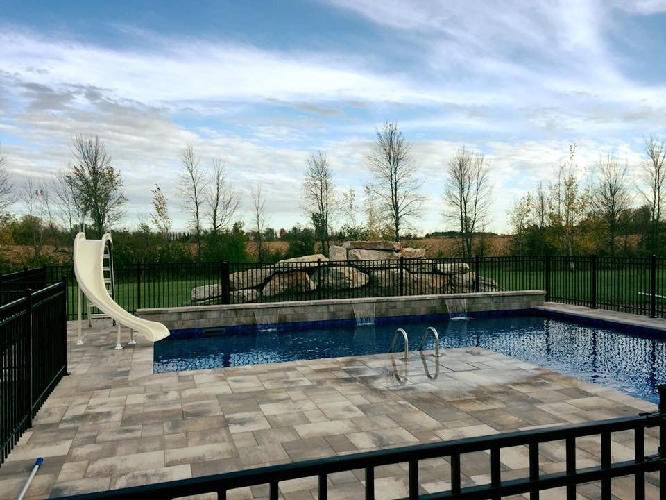 Une grande piscine avec toboggan dans l'arrière-cour.