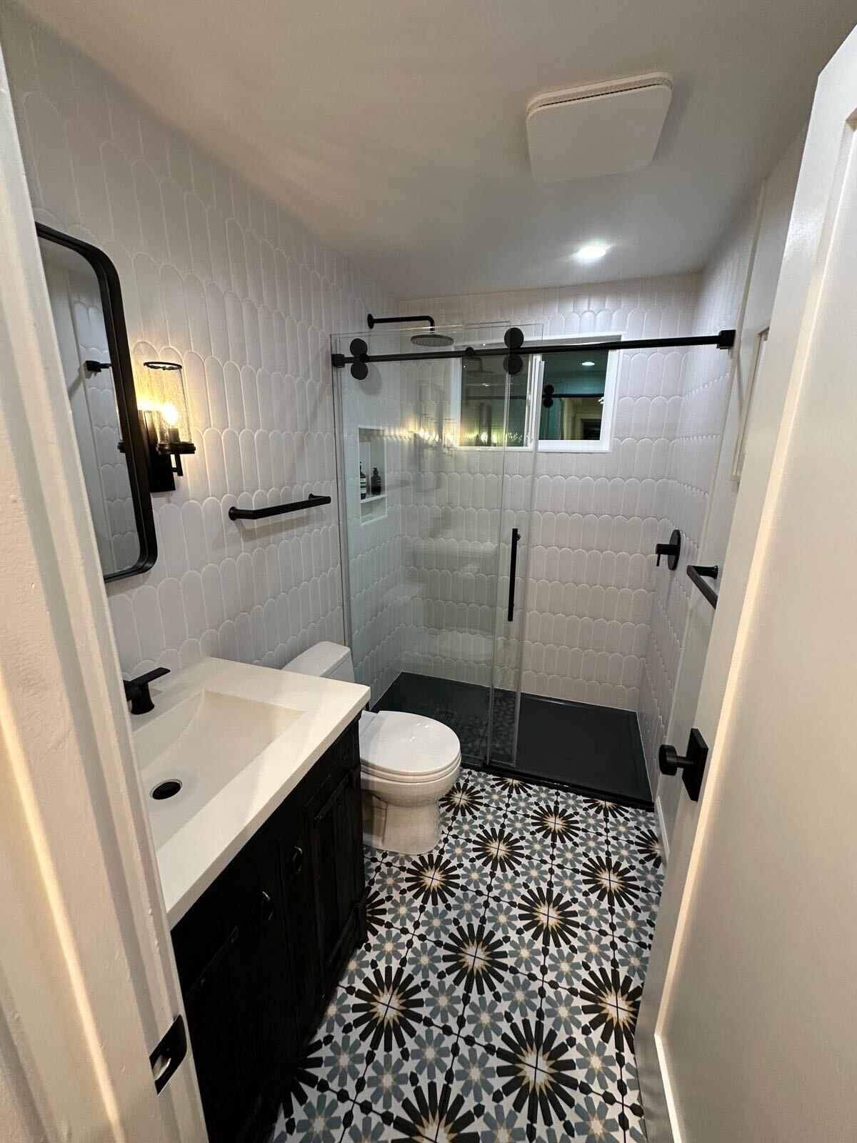 A bathroom with a toilet, sink, and a walk-in shower.
