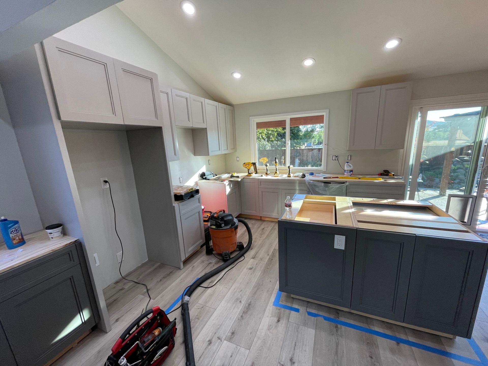 A kitchen under construction with a vacuum cleaner on the floor.