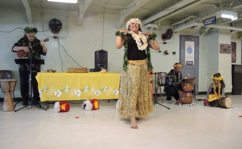 A woman is dancing in front of a group of people playing instruments.