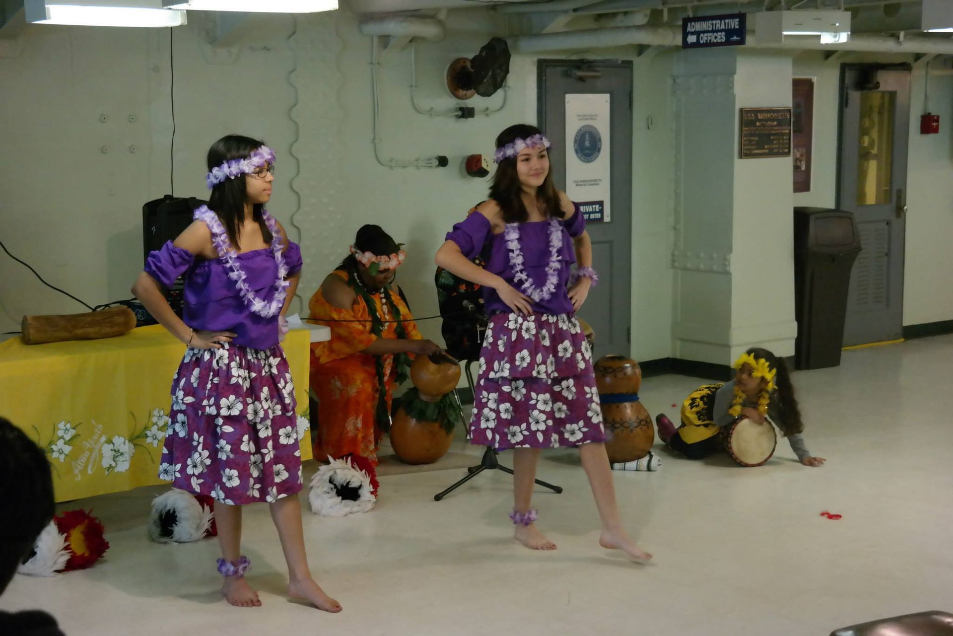 Two girls in purple skirts are dancing in a room