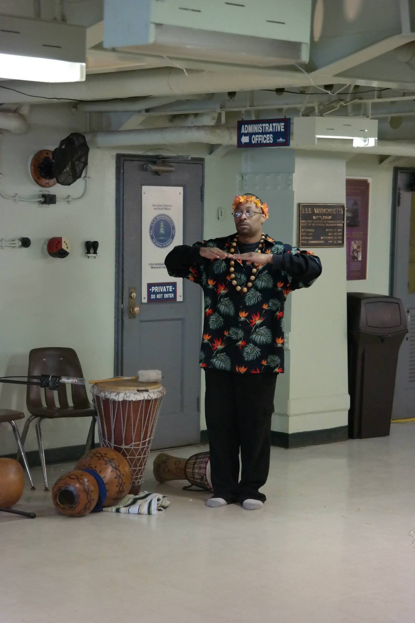 A man is standing in a room surrounded by drums.