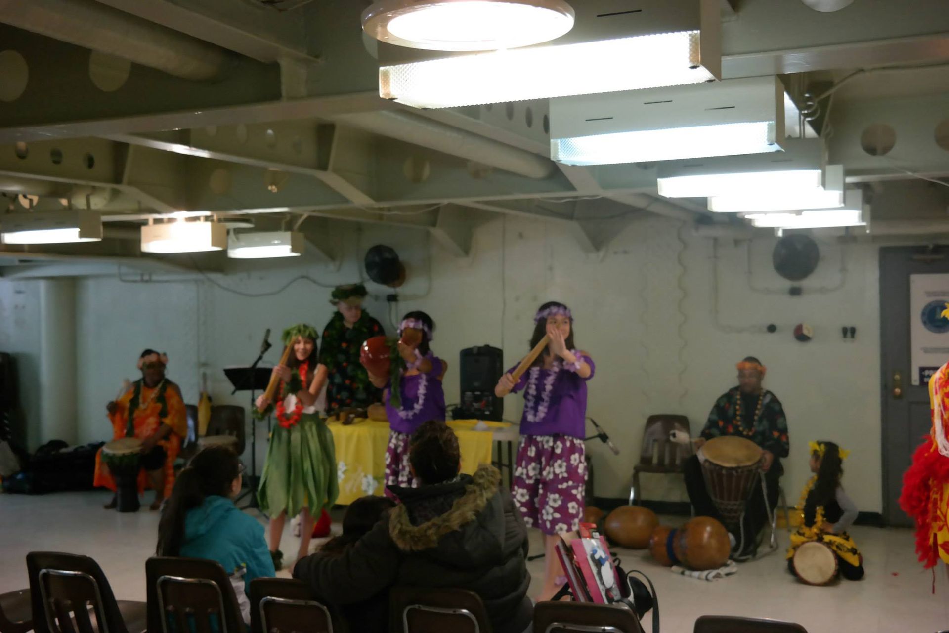 A group of people are dancing in a room with drums