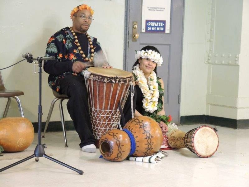 A man and a woman are playing drums in front of a door that says private