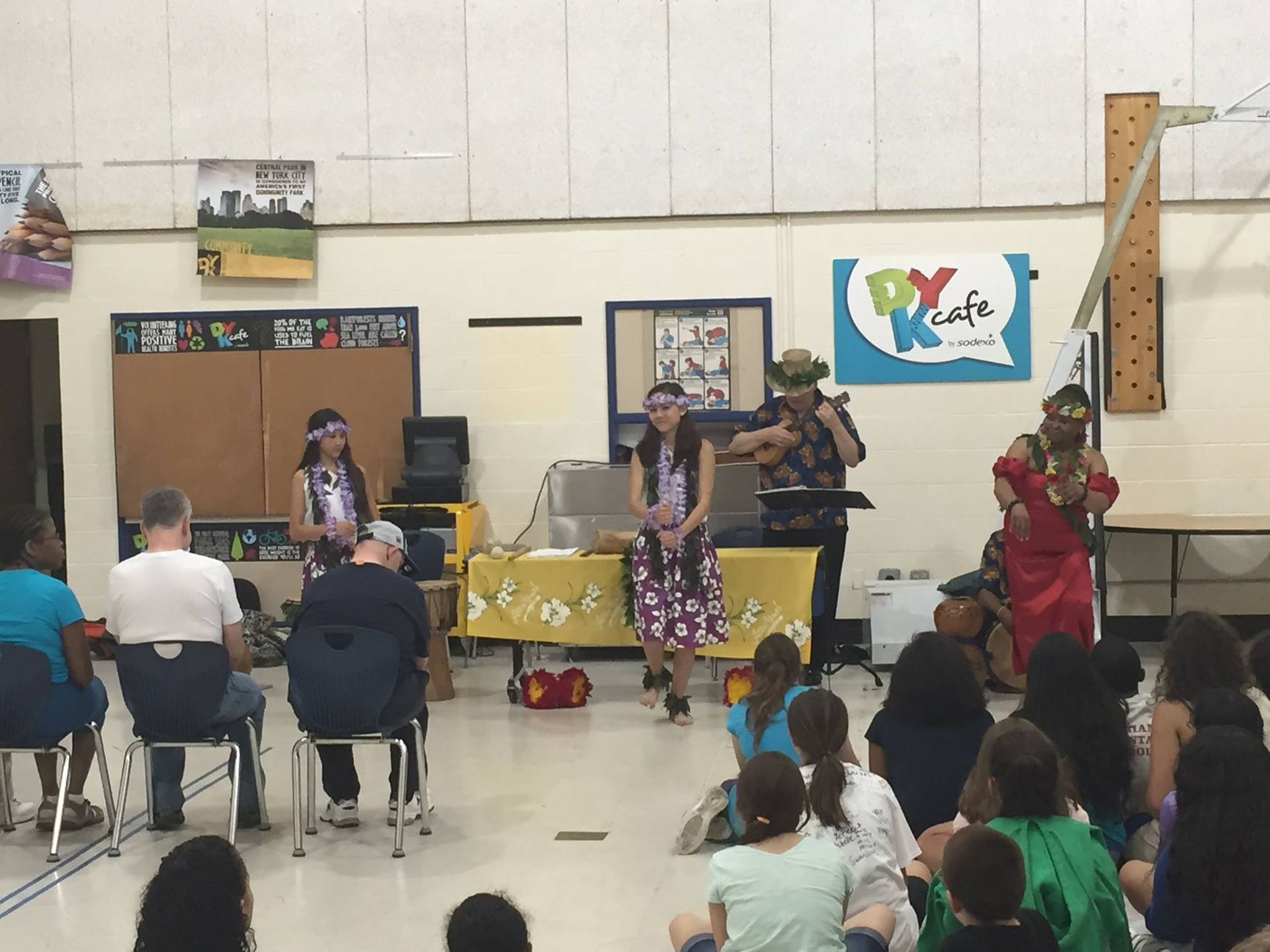 A group of people are sitting in front of a sign that says py cafe