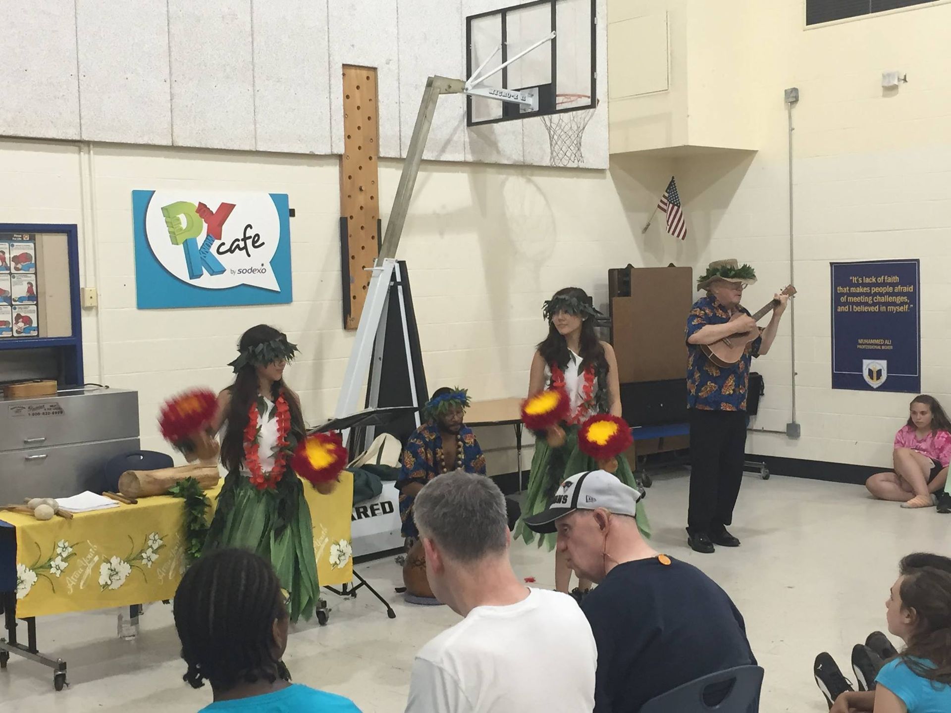 A group of people are sitting in front of a sign that says py cafe