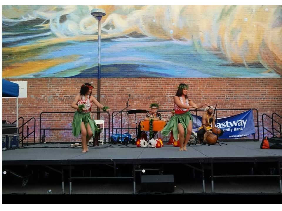 Two women are dancing on a stage in front of a sign that says ashway