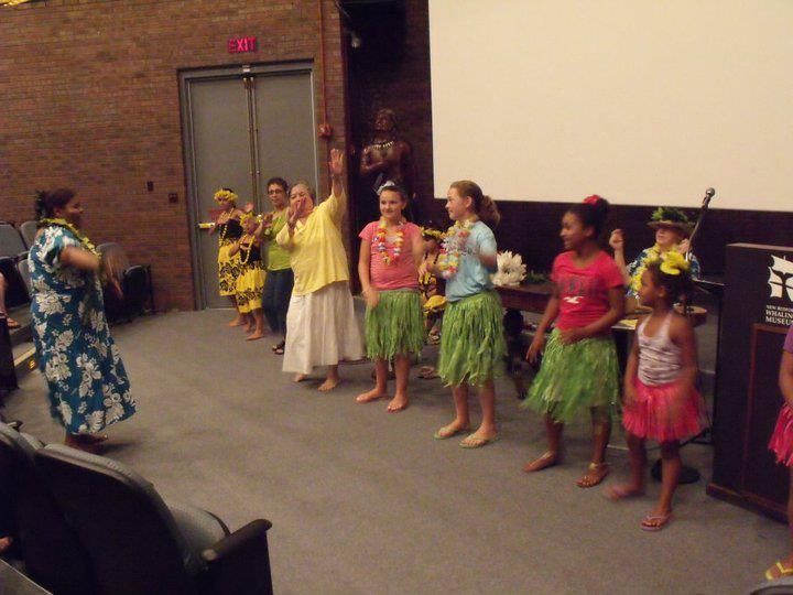 A group of people are dancing in front of a screen that says exit