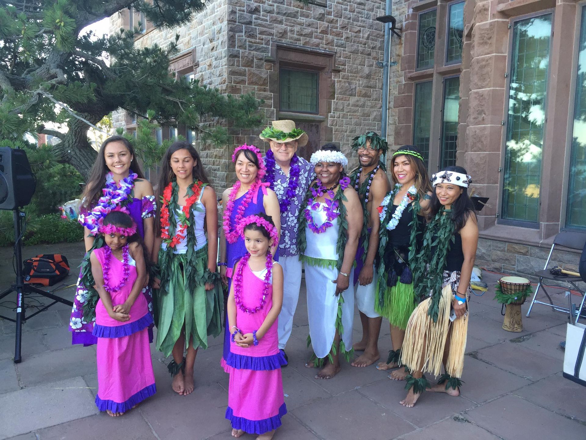 A group of people dressed in hawaiian costumes are posing for a picture.