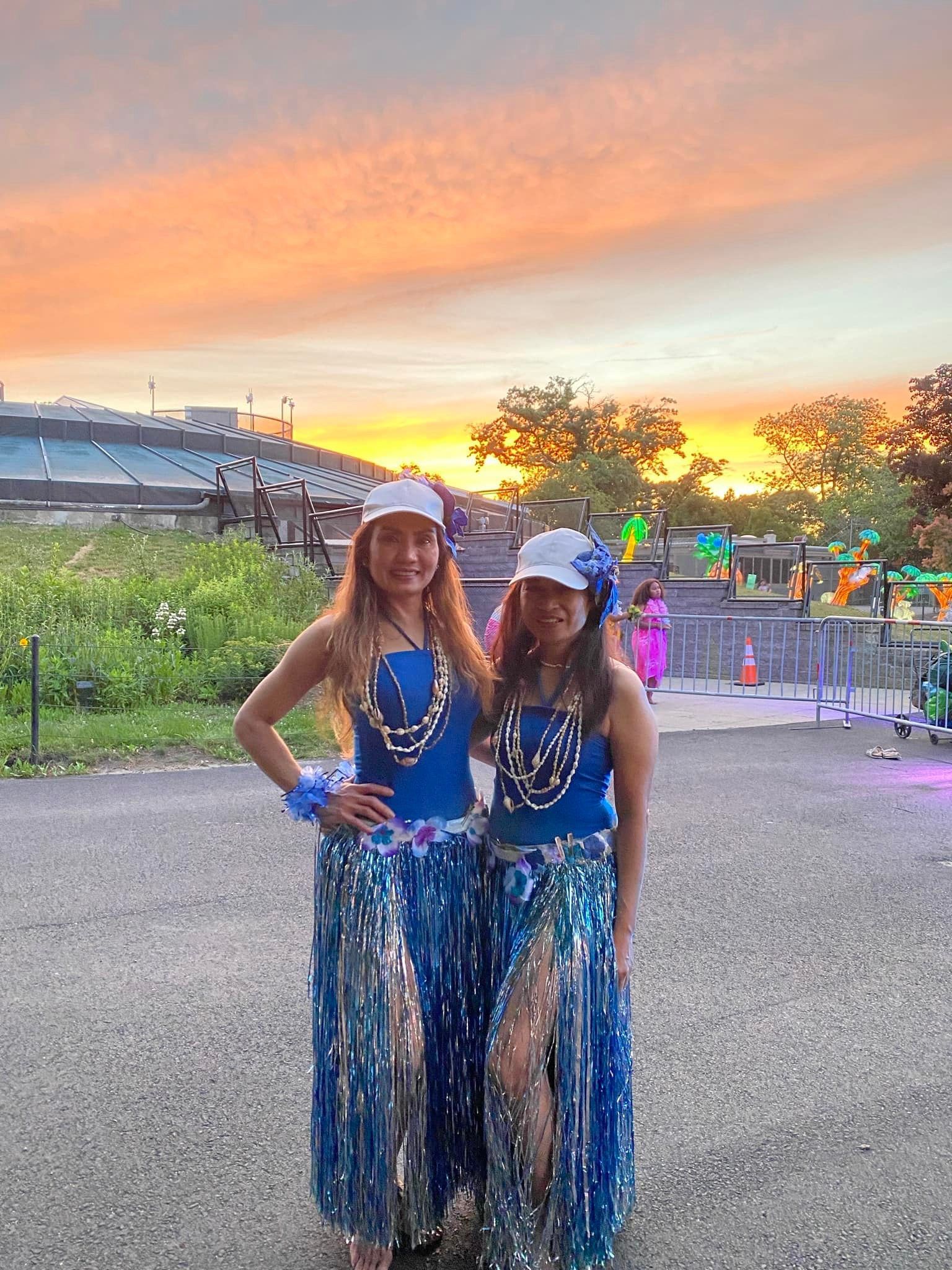 Two women are standing next to each other in a parking lot.