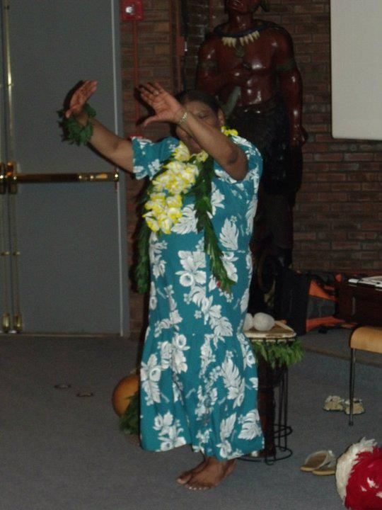 A woman in a blue and white floral dress is dancing