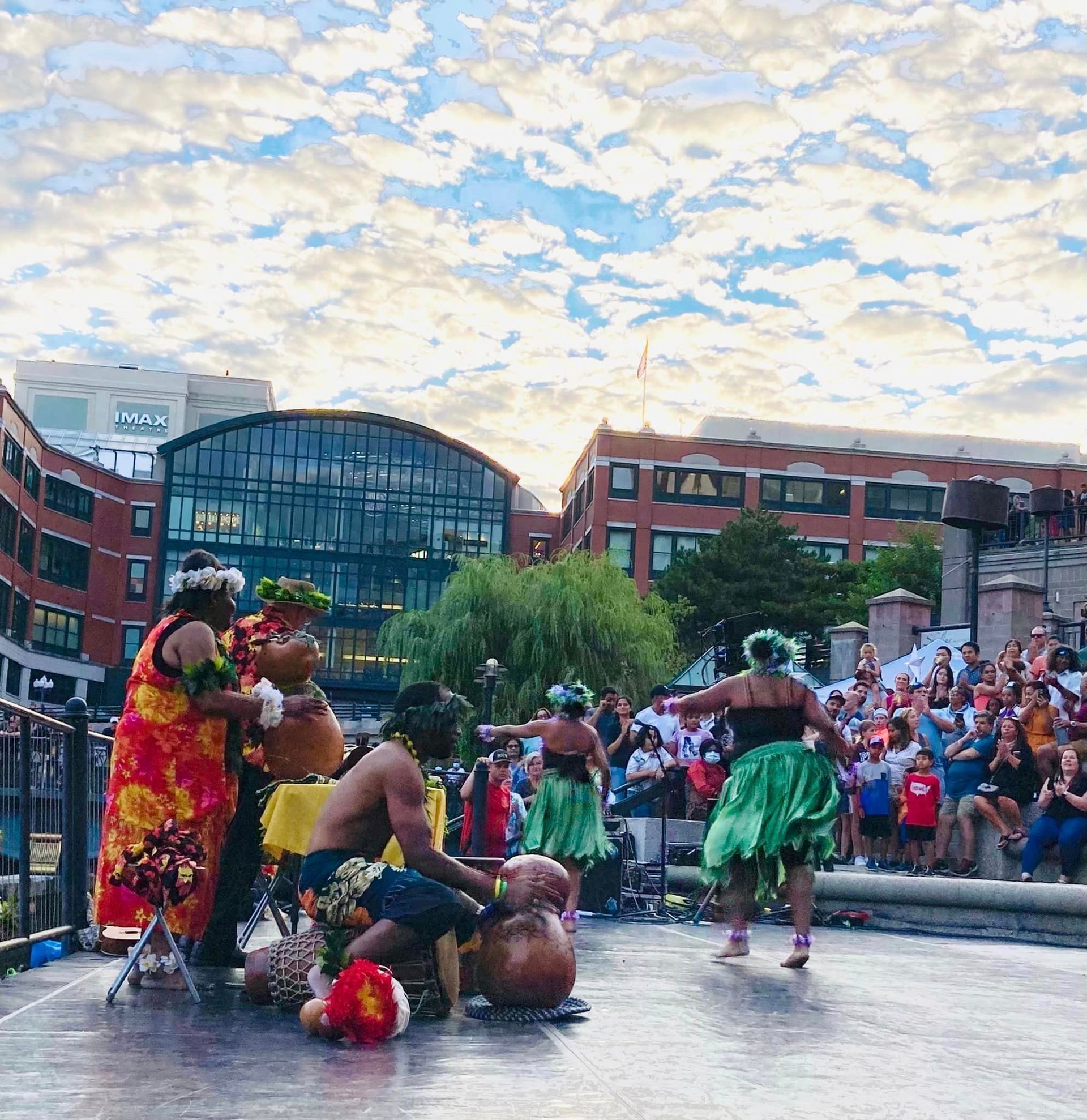 A group of people are dancing on a stage in front of a crowd.