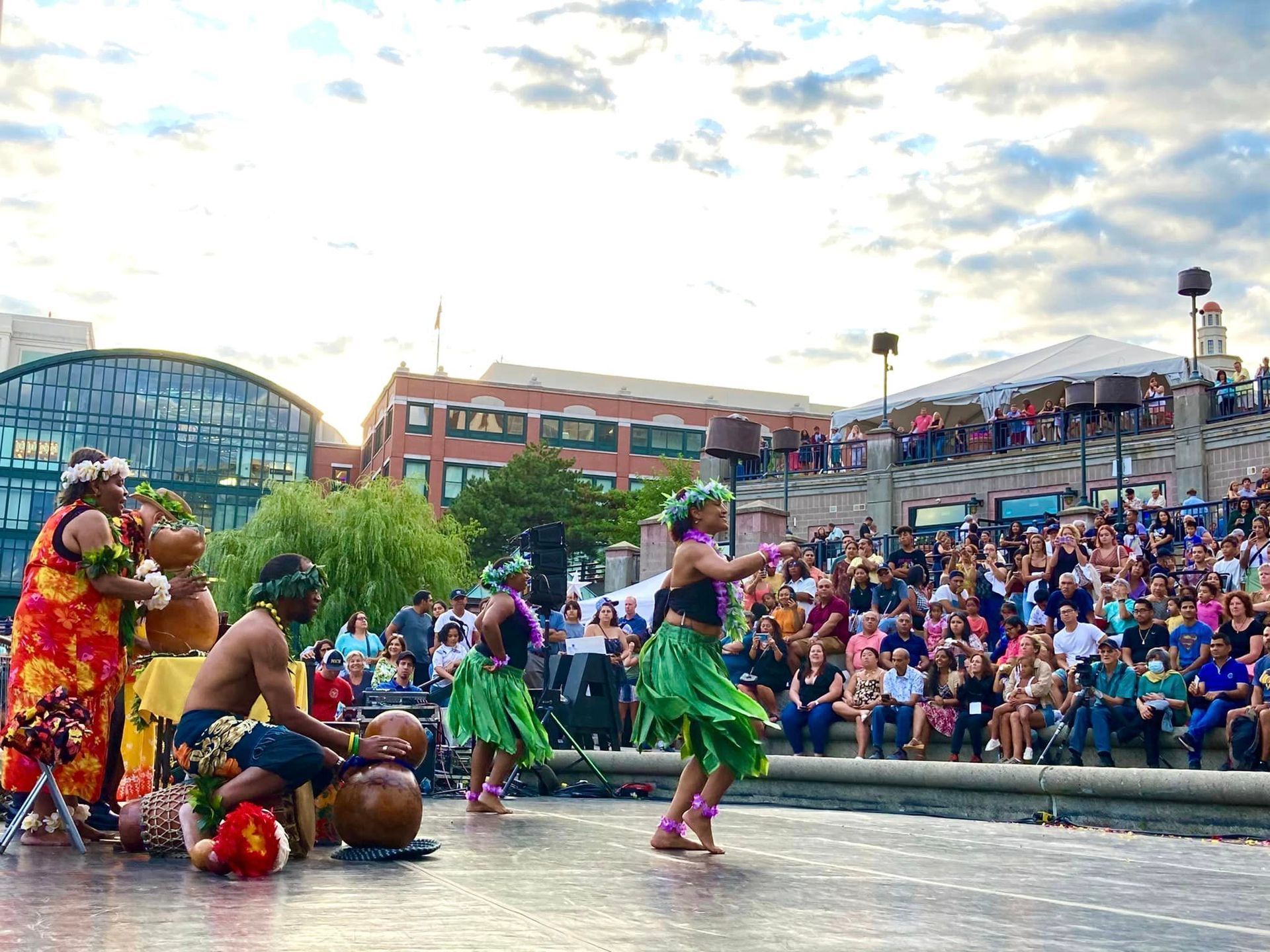 A group of people are dancing on a stage in front of a crowd.