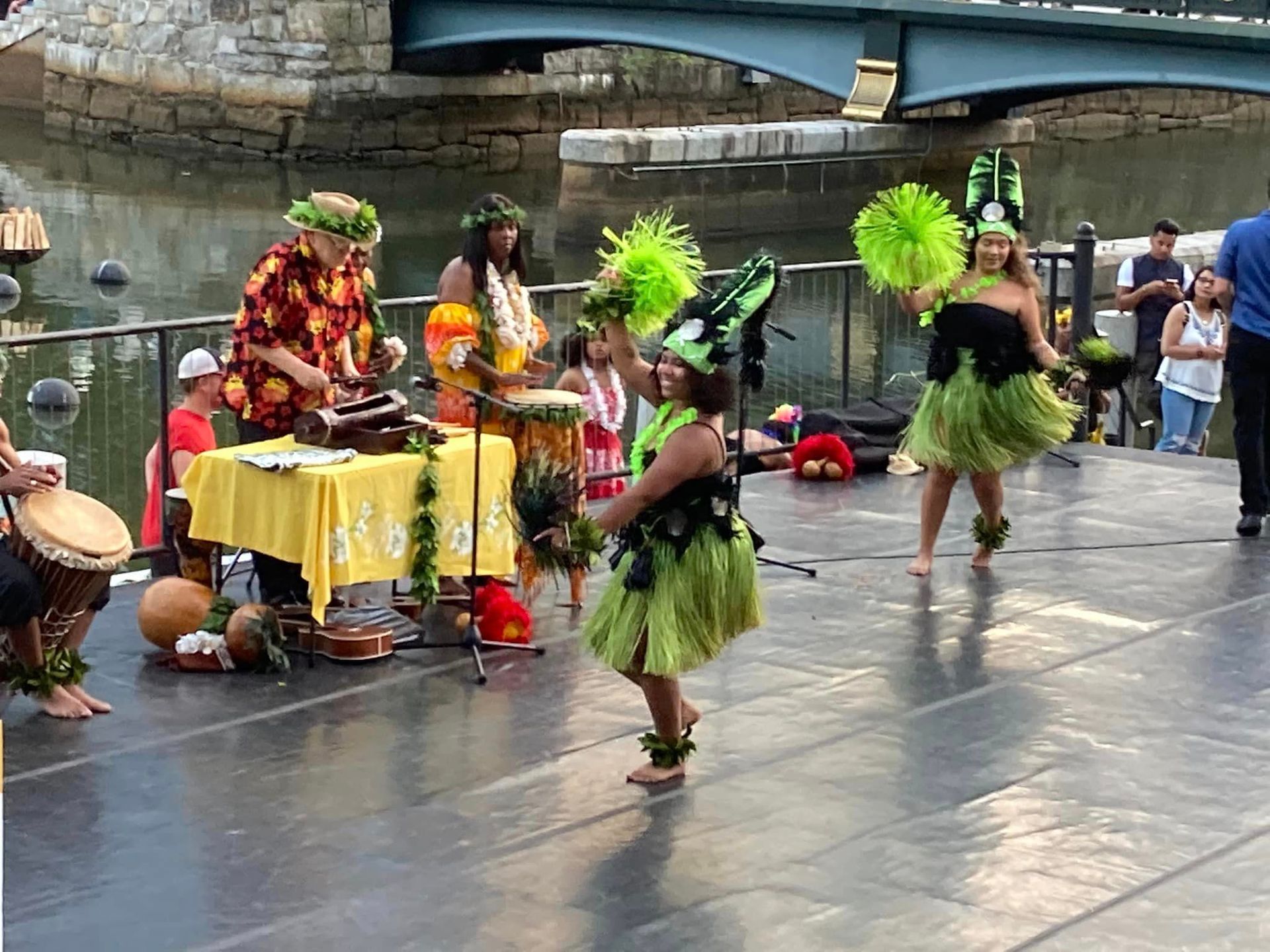 A group of people are dancing in front of a bridge
