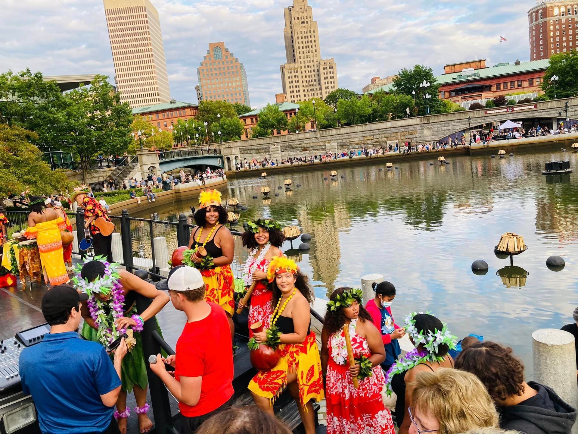 A group of people are standing next to a body of water.