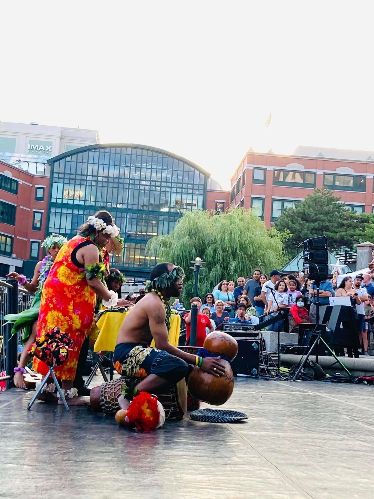 A group of people are dancing on a stage in front of a crowd.