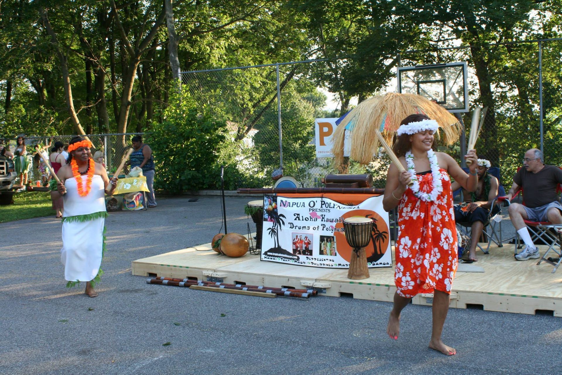 Two women are dancing in front of a sign that says p.