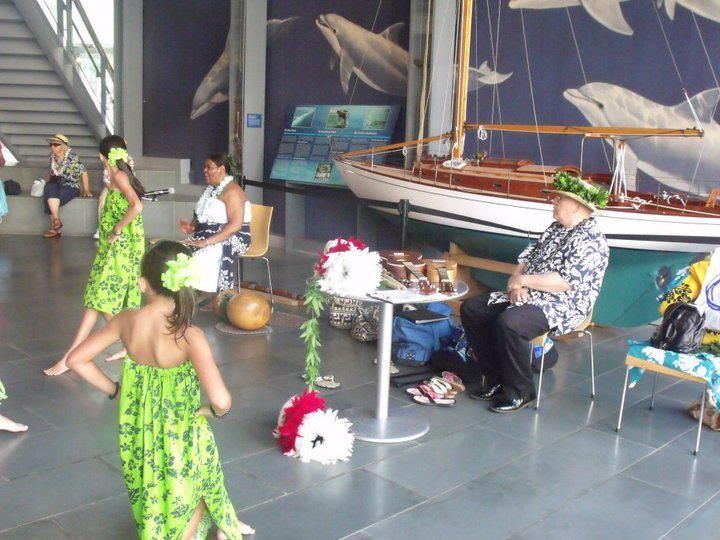 A group of people are dancing in front of a boat