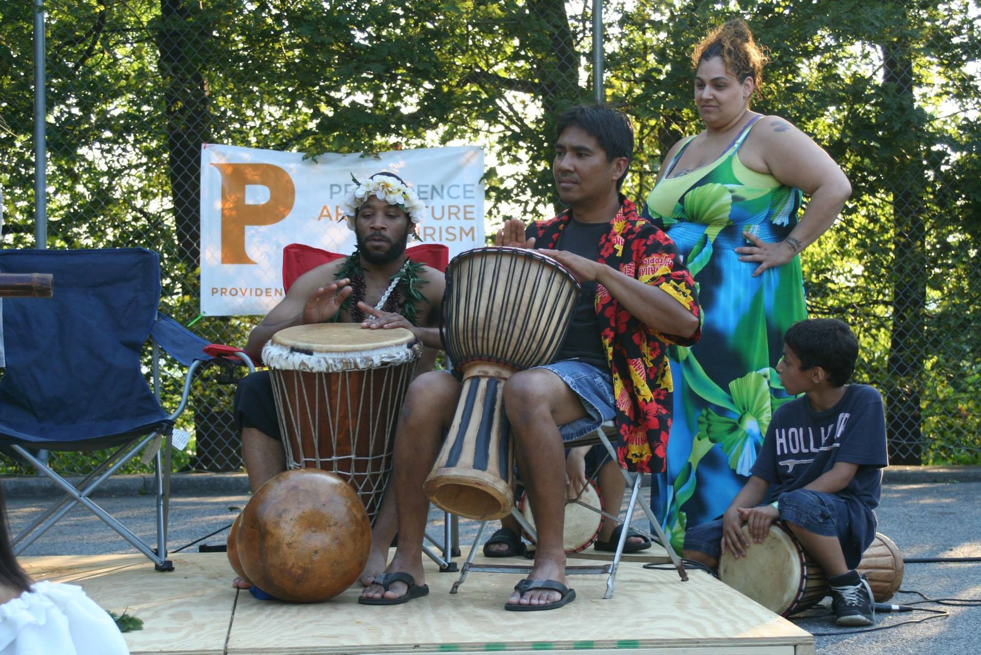 A group of people playing drums in front of a sign that says p.