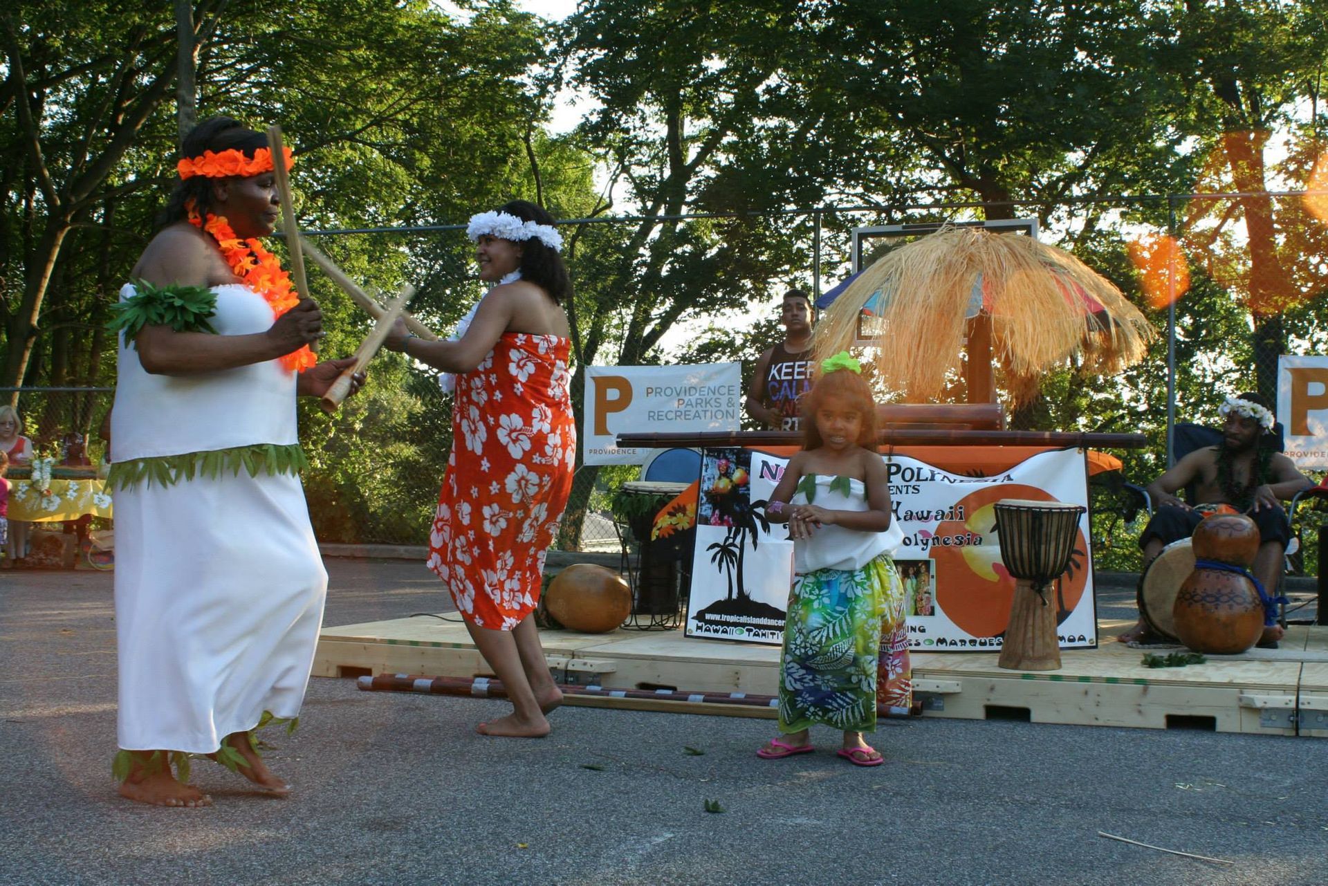 A group of people are dancing in front of a sign that says p.