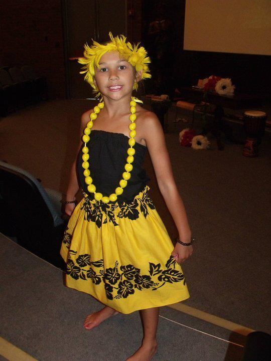 A little girl wearing a yellow dress and a yellow necklace