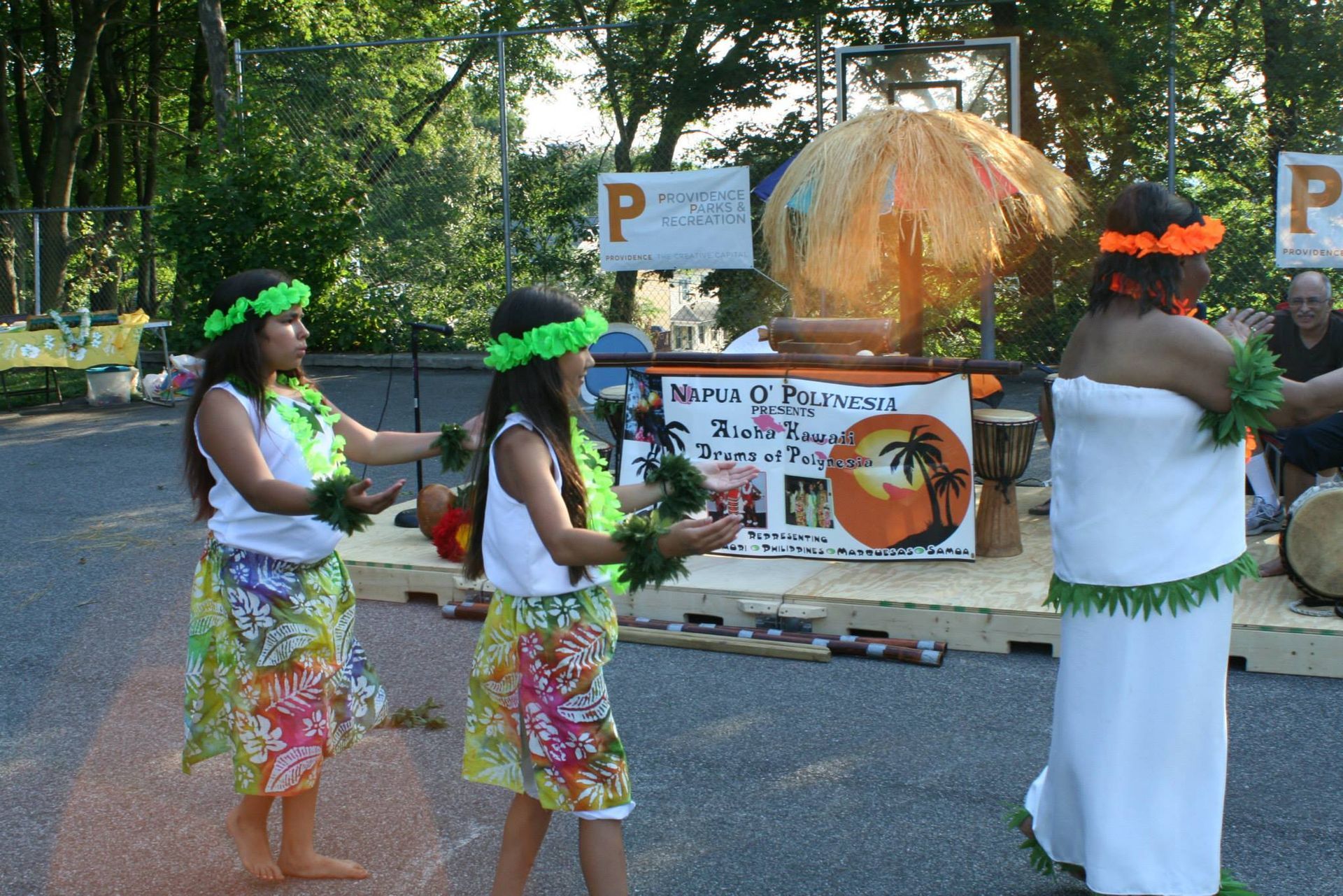 A group of people dancing in front of a sign that says p