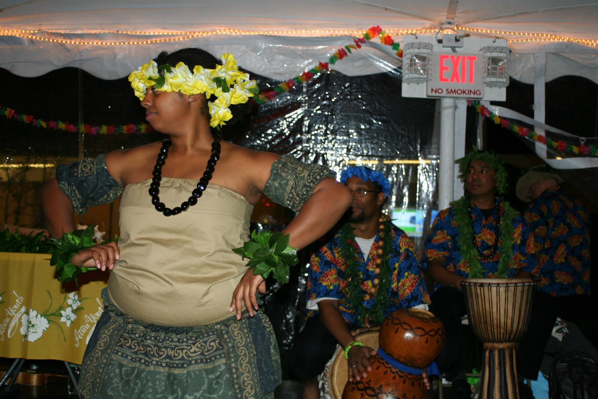 A woman is dancing in front of an exit sign