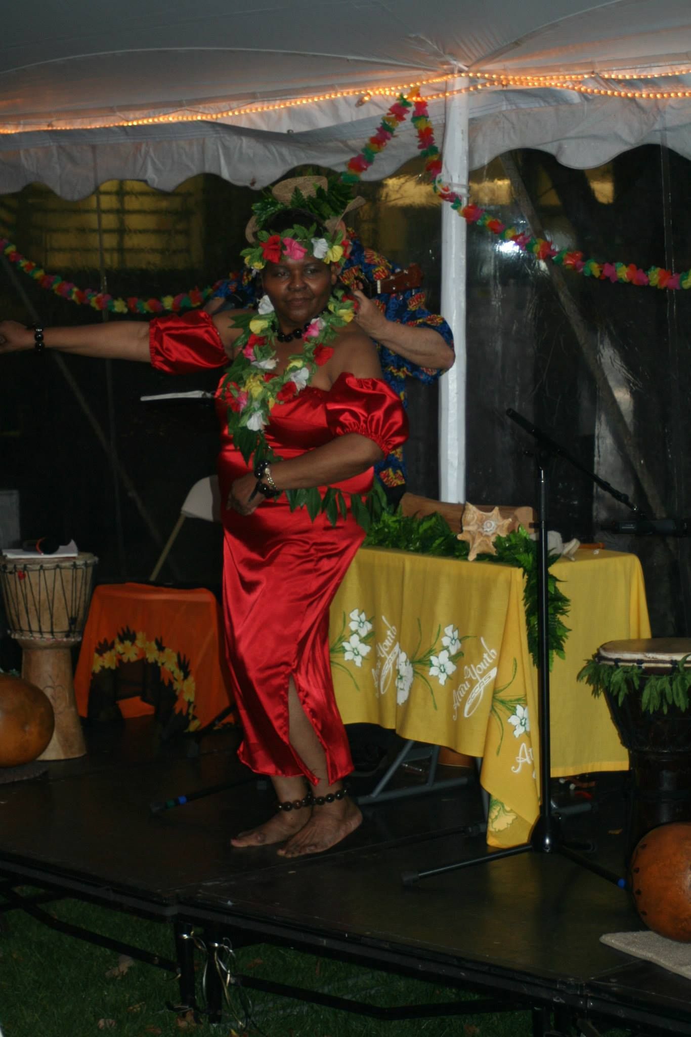 A woman in a red dress is dancing on a stage