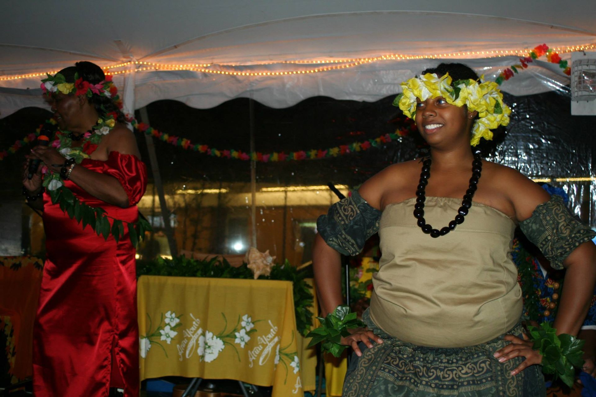 A woman in a red dress is standing next to a woman in a tan dress