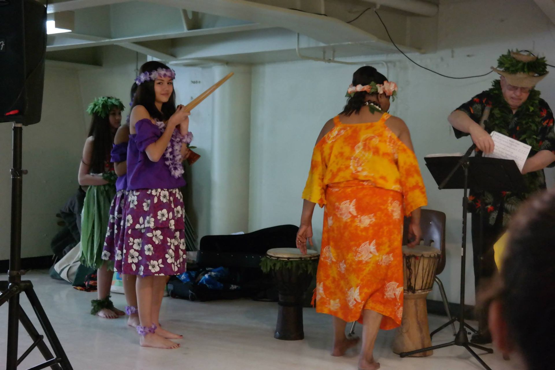 A group of people are dancing in a room with drums