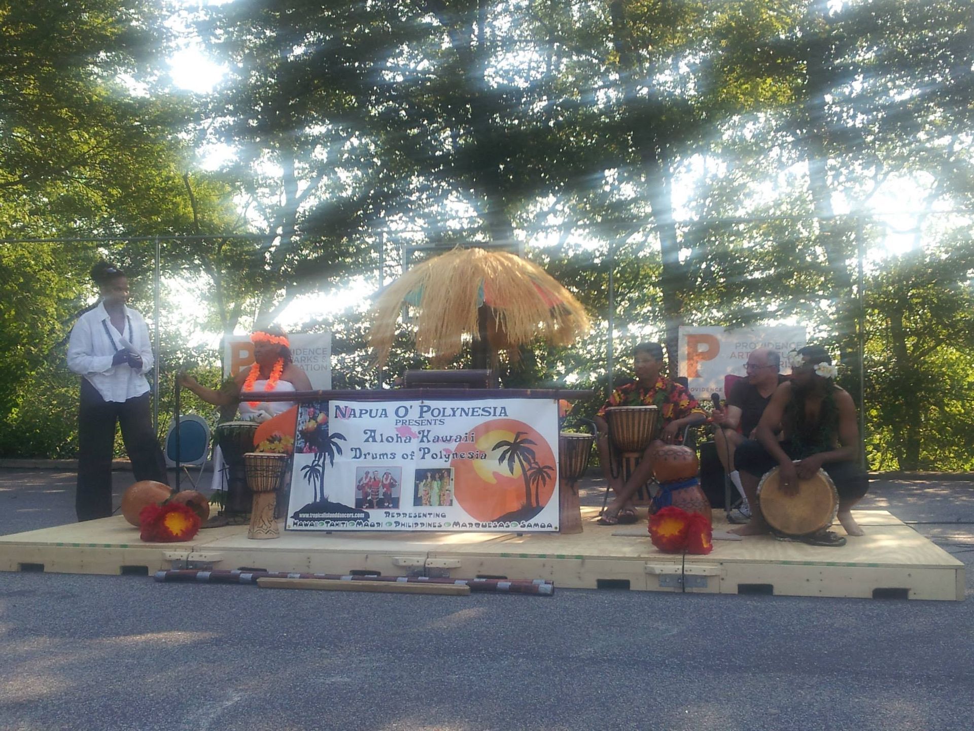 A group of people playing drums in front of a sign that says beach party