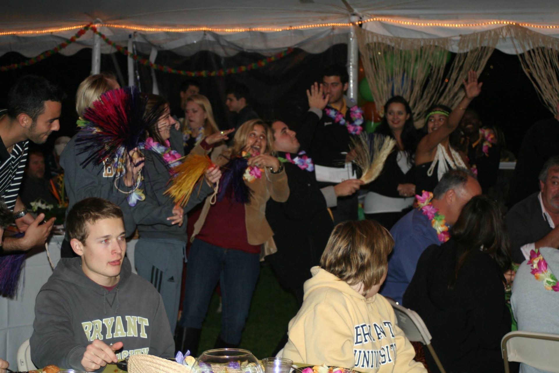 A boy wearing a vitart sweatshirt sits at a table with other people