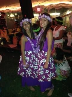 Two girls in purple dresses are standing next to each other.
