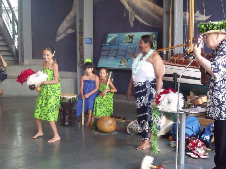 A group of people are dancing in front of a boat