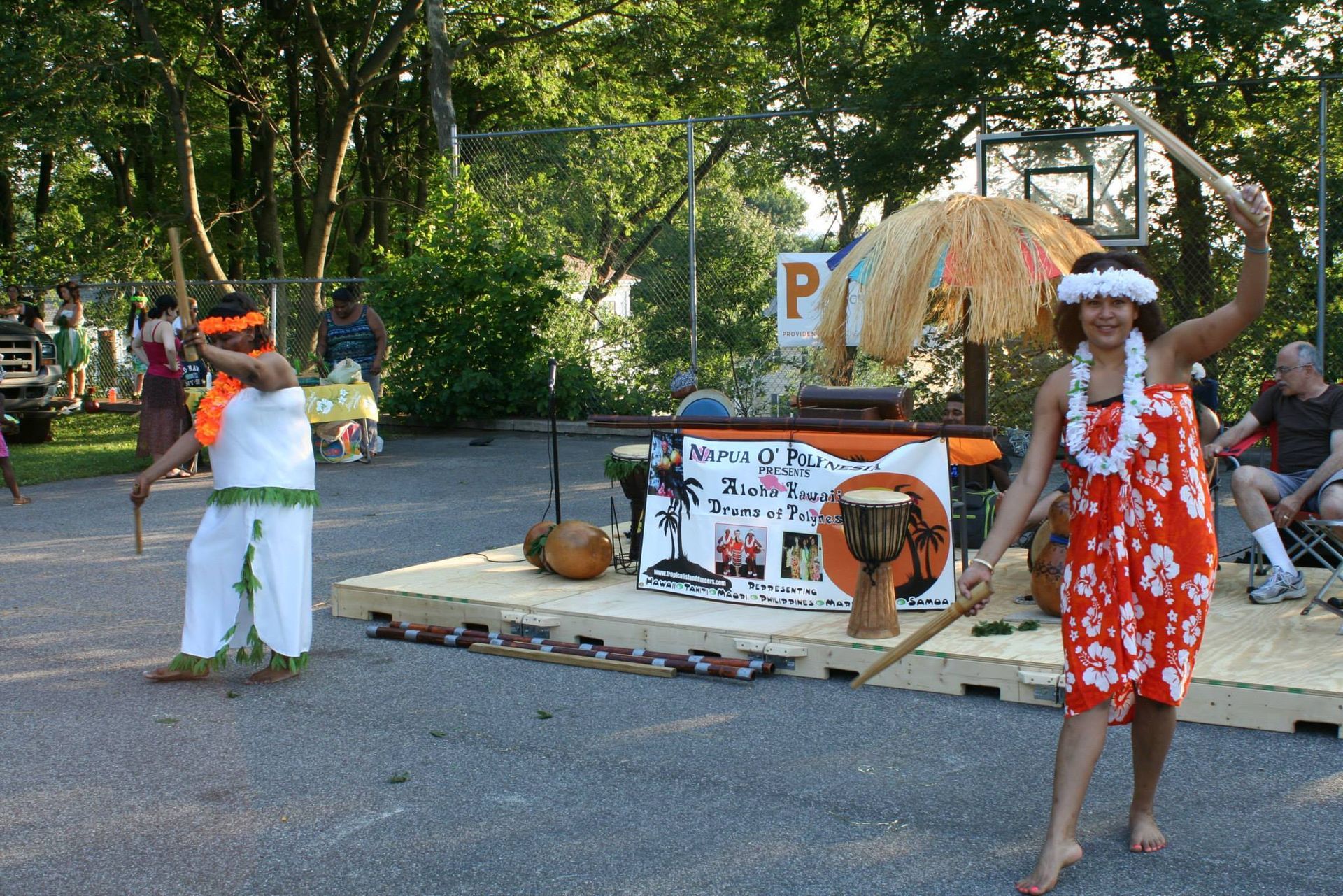 A group of people are dancing in front of a sign that says p.