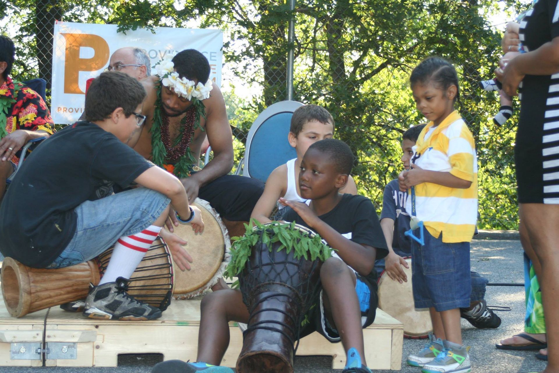A group of people playing drums in front of a sign that says p