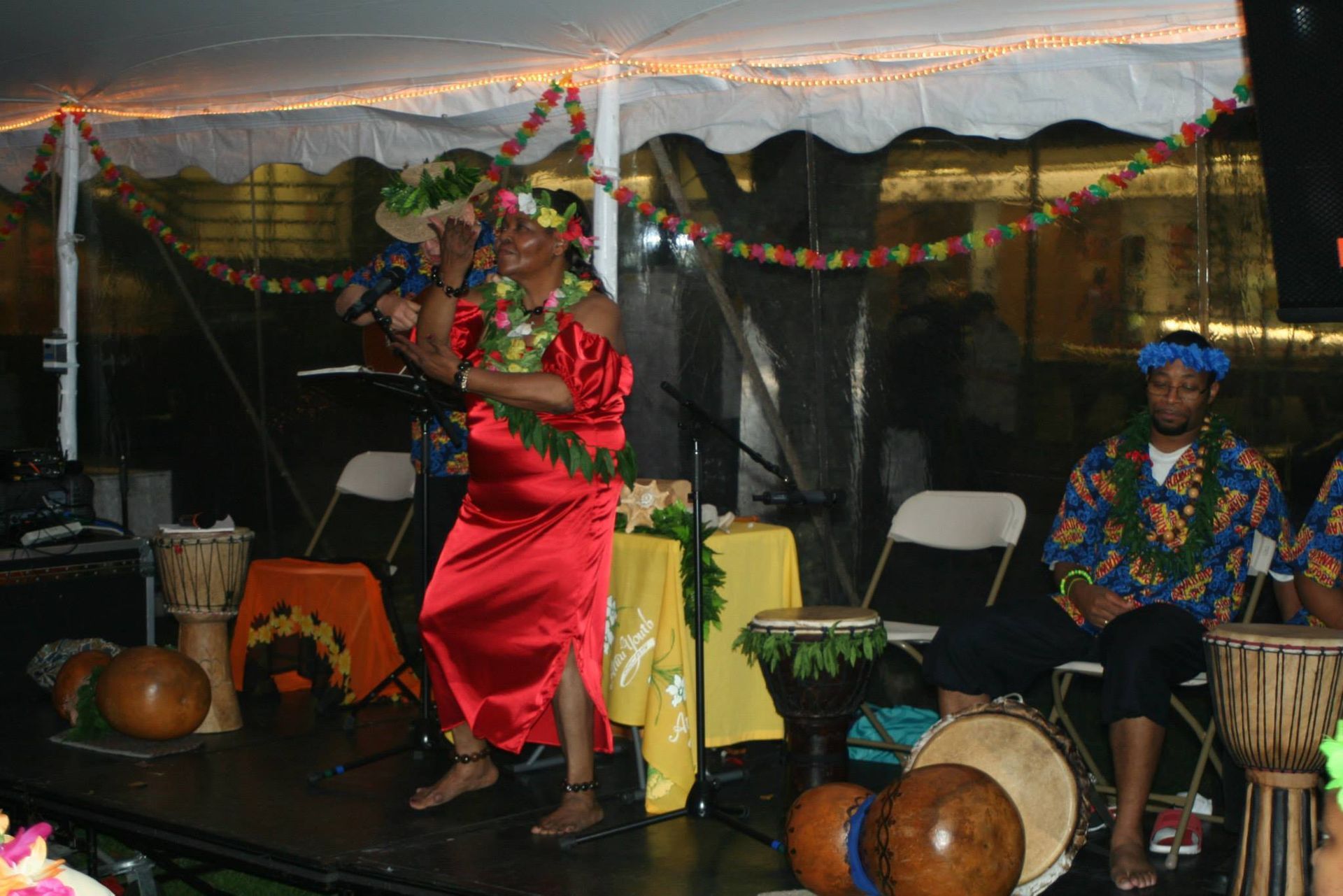 A woman in a red dress is dancing on a stage