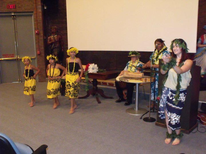 A group of people are dancing in front of a projector screen