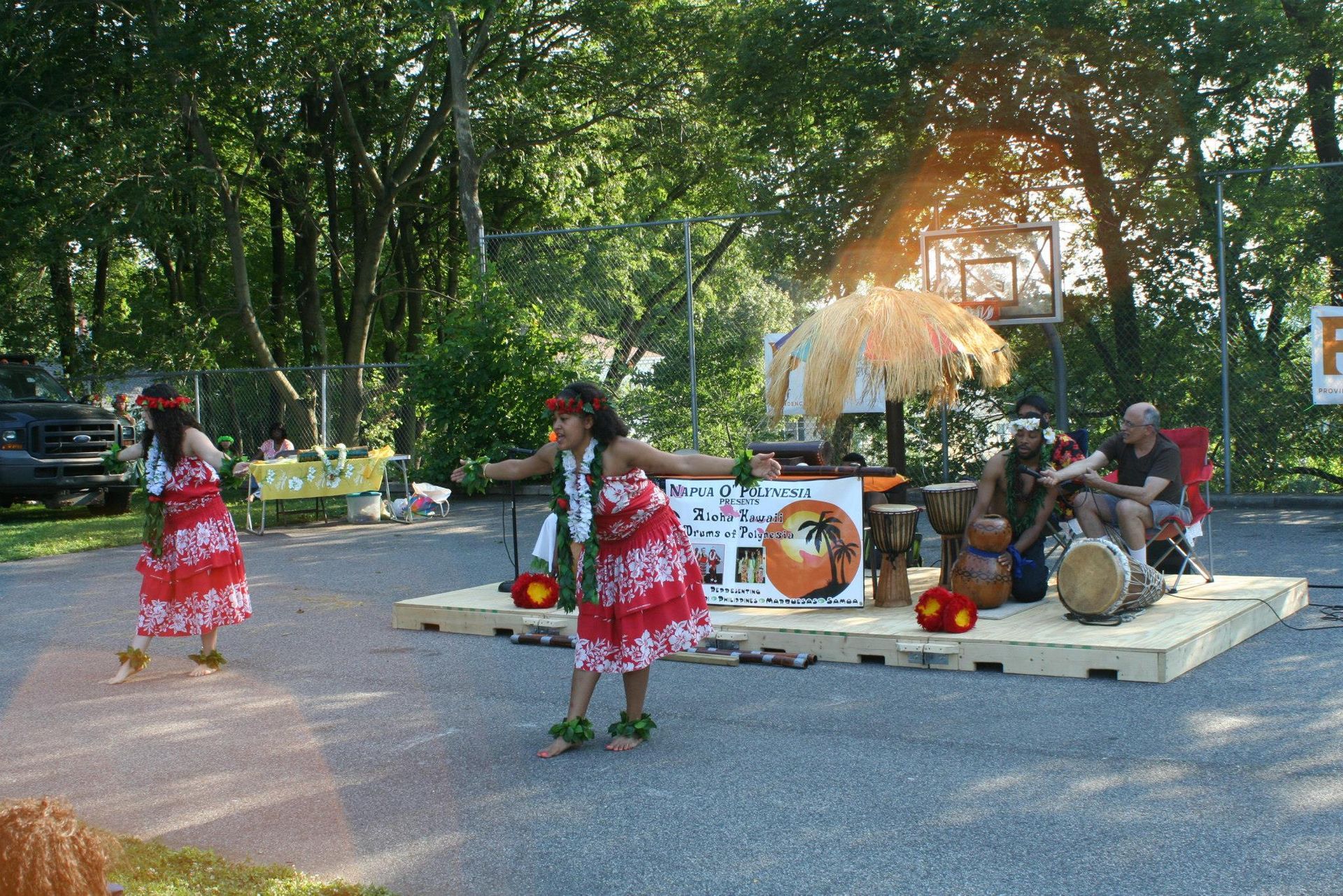 Two women are dancing in front of a sign that has the letter f on it
