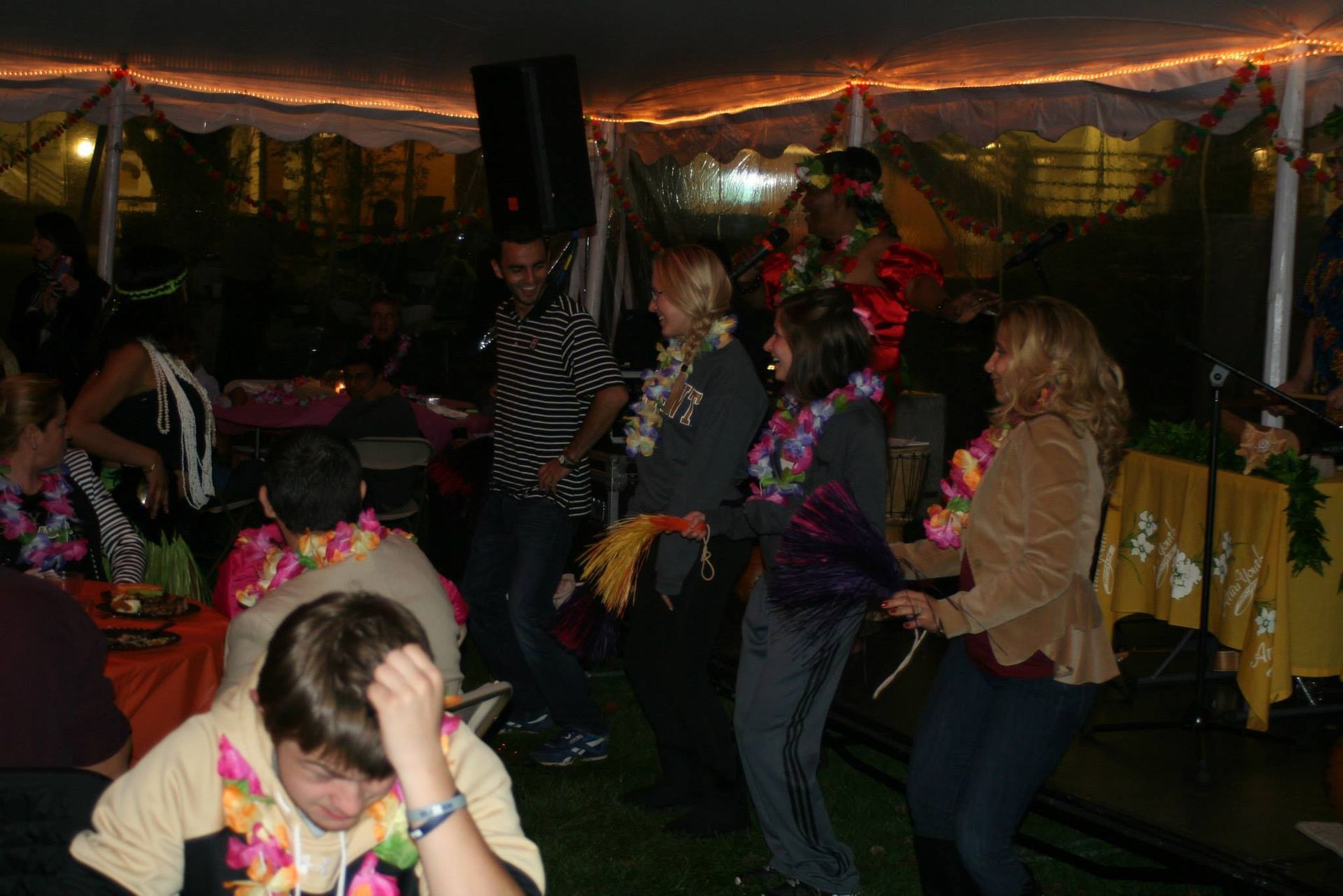A group of people are dancing under a tent.