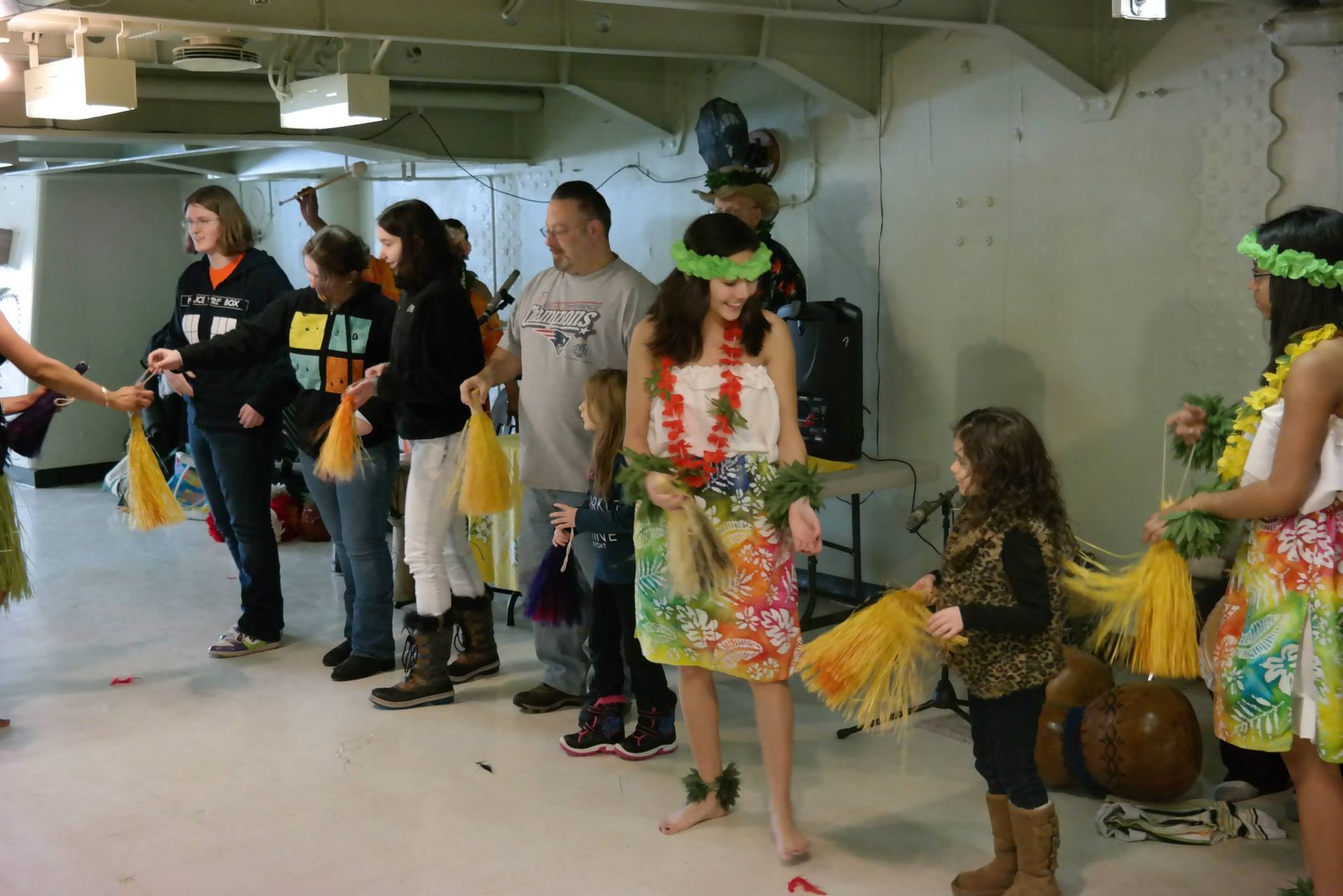 A group of people in hawaiian costumes are dancing