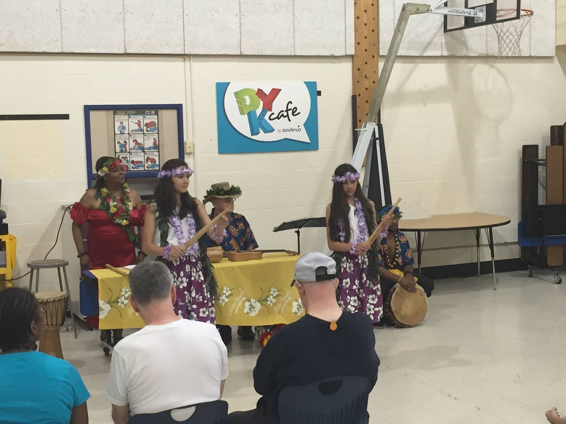 A group of people are sitting in front of a sign that says px cafe