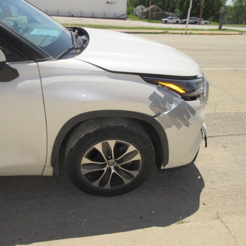 A white car is parked on the side of the road