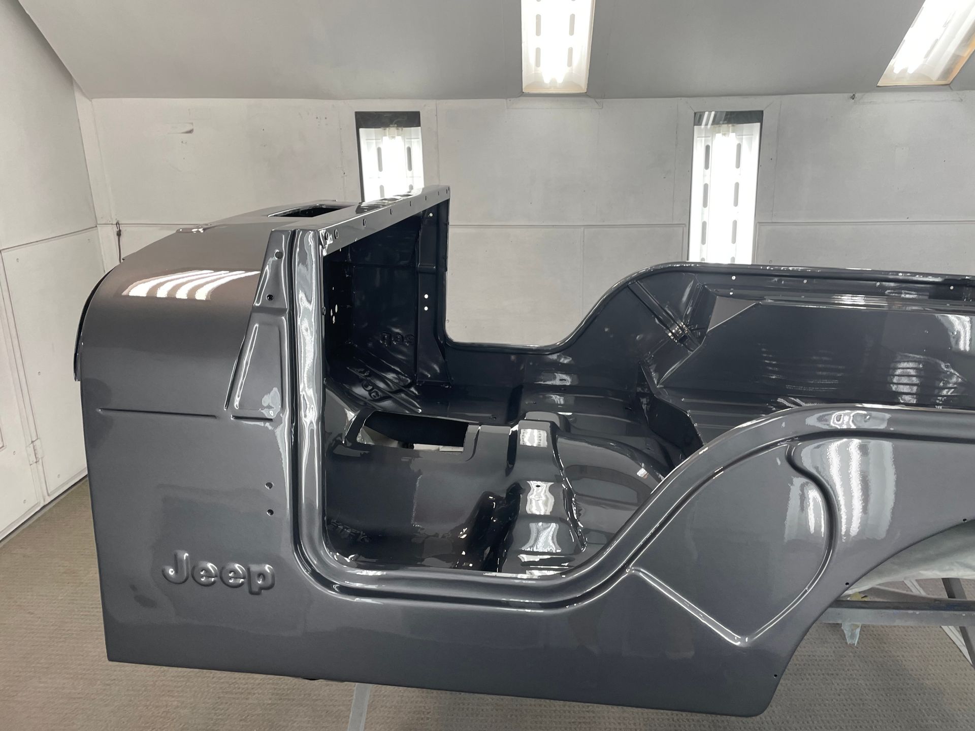 A jeep body is being painted in a room